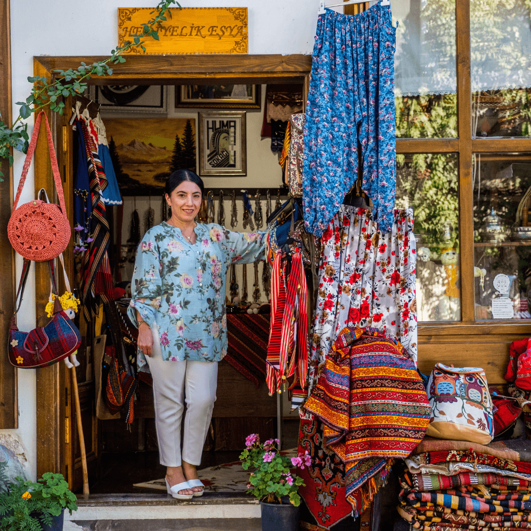 A small business owner standing in a colorful storefront